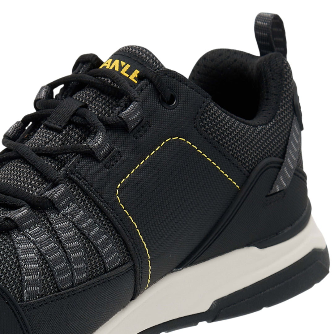 Black sneaker with yellow accents on a white background