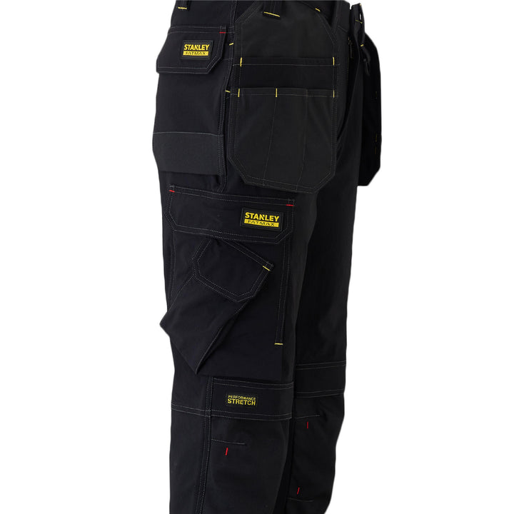 Black work pants with multiple pockets and Stanley branding on a white background