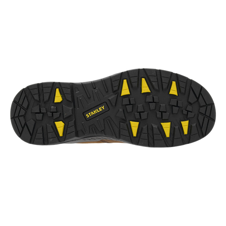 The treaded black rubber outsole of a Stanley work boot, featuring bright yellow triangular lugs and a yellow Stanley logo, shown against a plain white background.