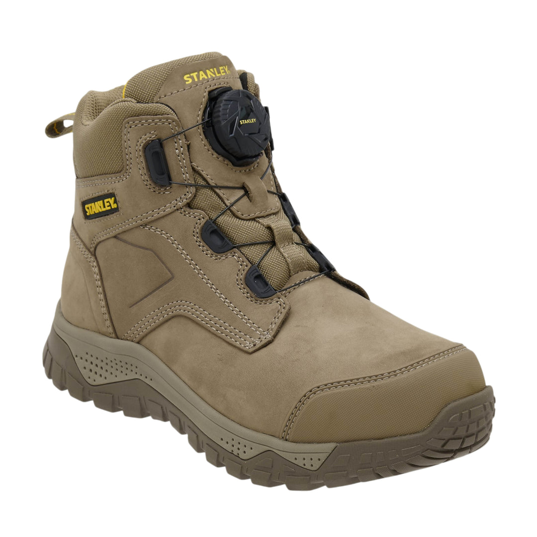 A tan and brown Stanley work boot with a black dial lockout system and black laces, shown from a three-quarters angle on a white background.