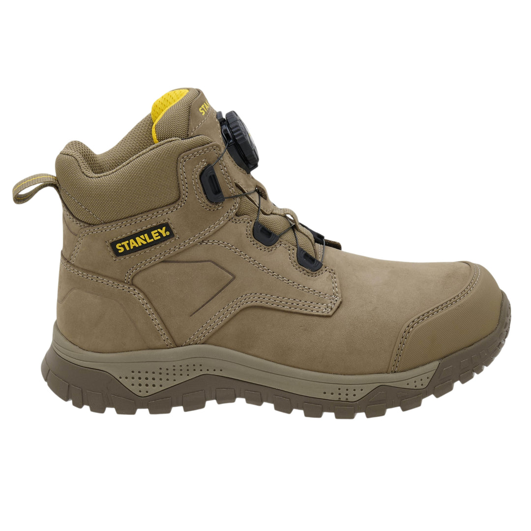 A tan and brown suede and mesh mid-cut work boot by Stanley, featuring a black dial closure system and a yellow brand logo on the side.