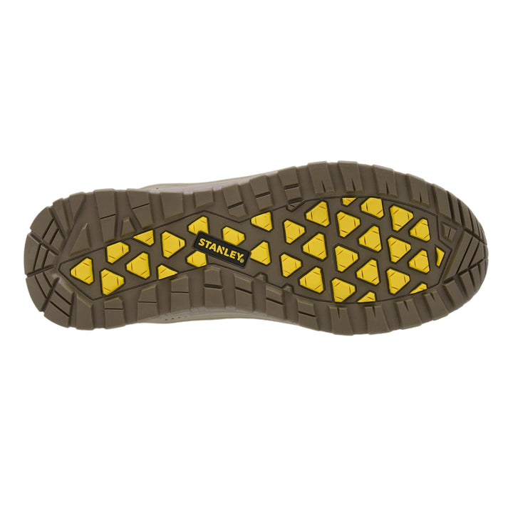 The treaded outsole of a Stanley work boot, featuring a dark brown rubber base with bright yellow triangular grip patterns and the Stanley logo in the center.