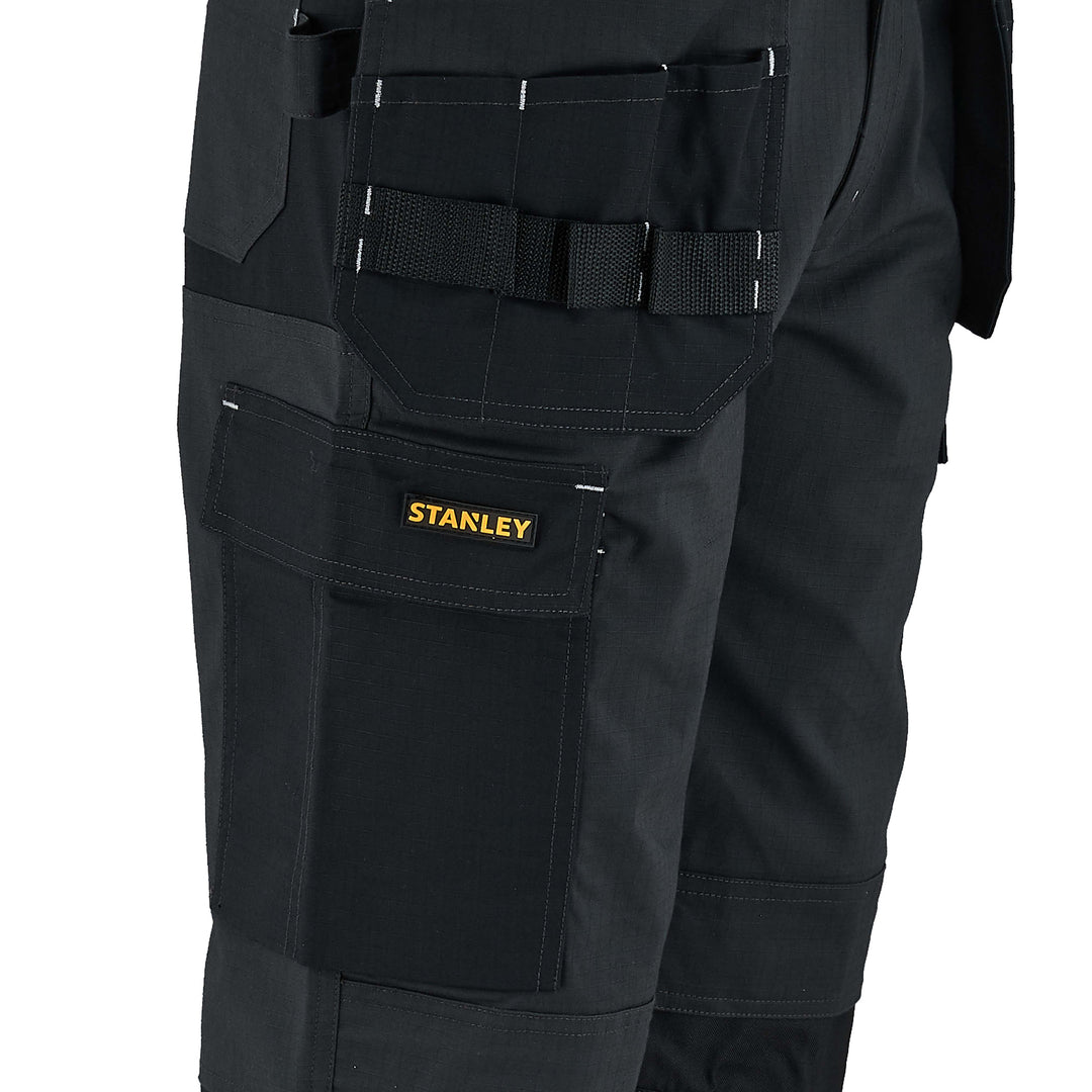 Black work pants with multiple pockets and a visible Stanley logo on a white background