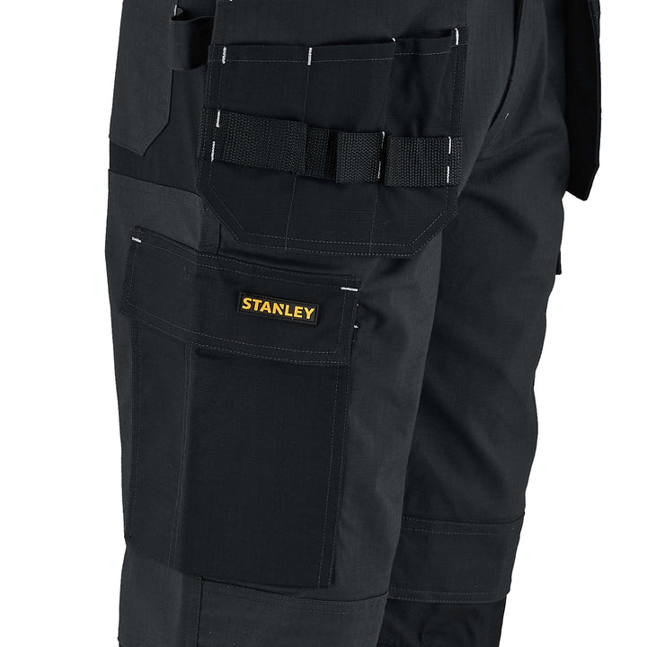 Black work pants with multiple pockets and a visible Stanley logo on a white background