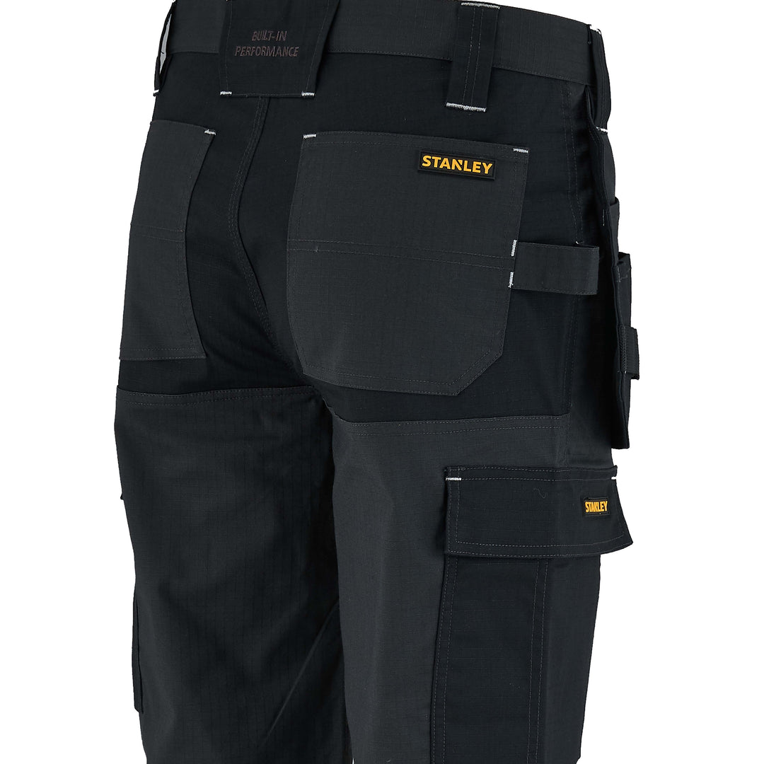 Black work pants with multiple pockets and a visible Stanley logo on a white background
