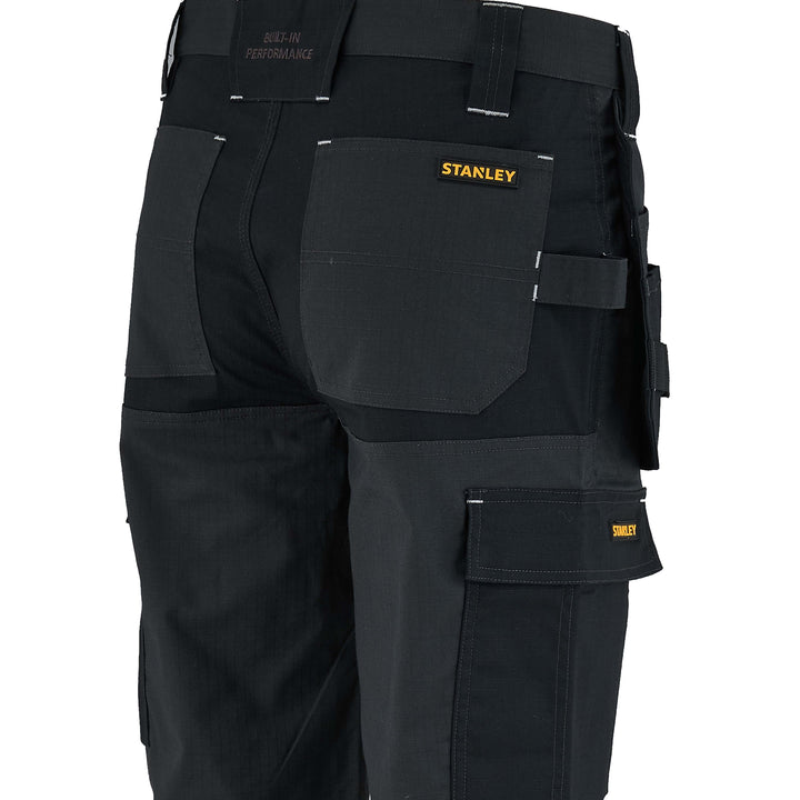 Black work pants with multiple pockets and a visible Stanley logo on a white background